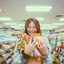 Eine Frau mit Süßigkeiten in der Hand, in einem Supermarkt.
